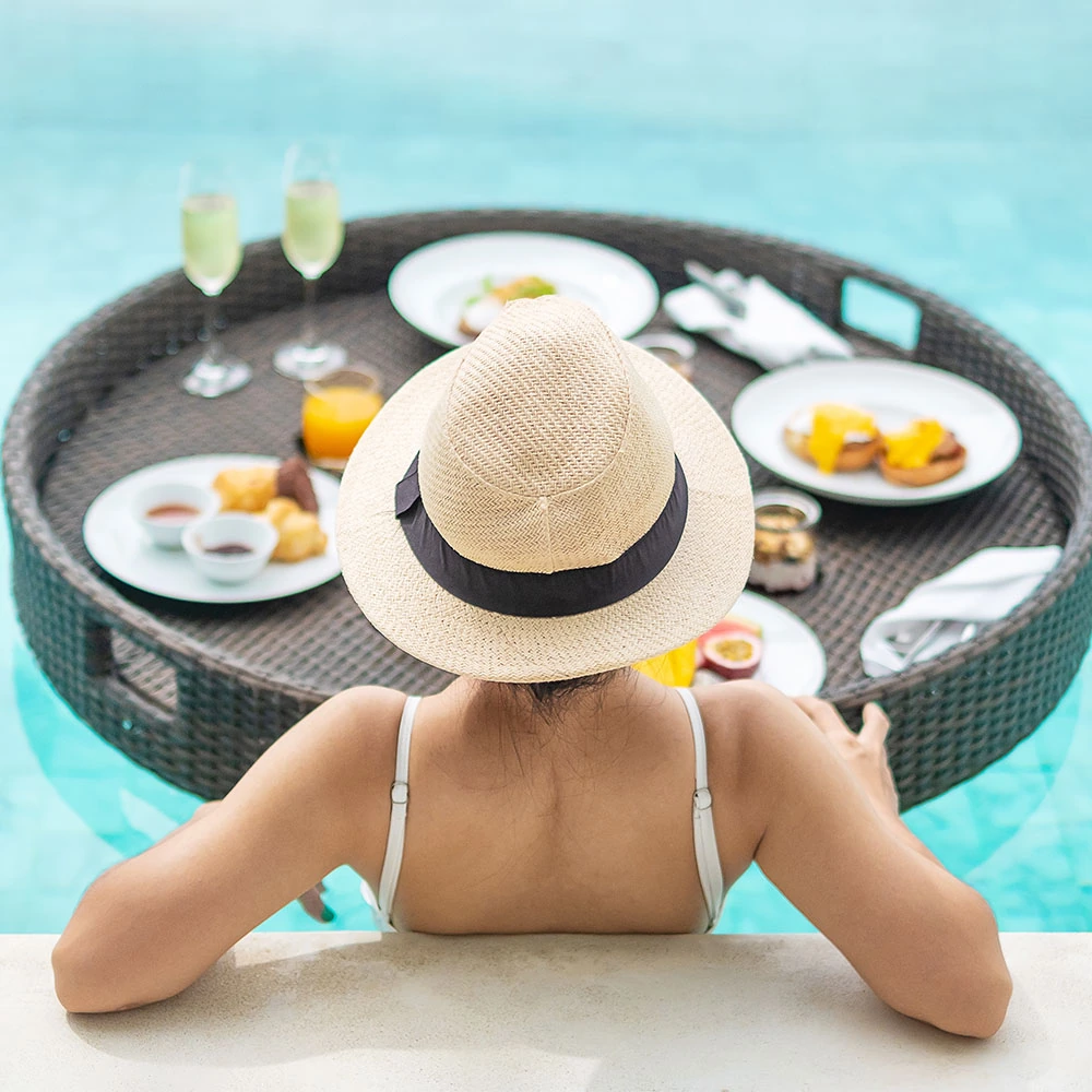 woman-with-floating-breakfast-in-pool-AKPVZX3