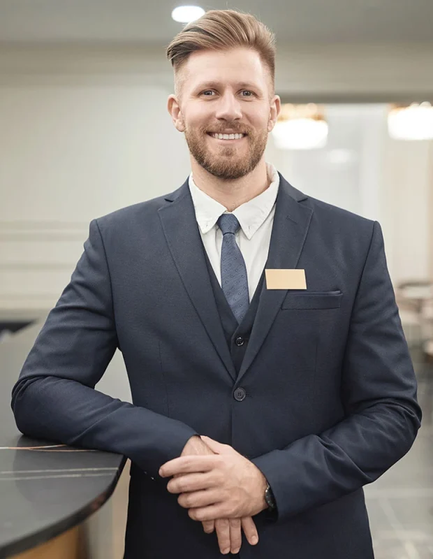 man-working-at-hotel-reception-ZDB9C8L